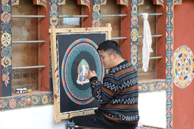 Bhutanese artist painting a traditional thangka mandala
