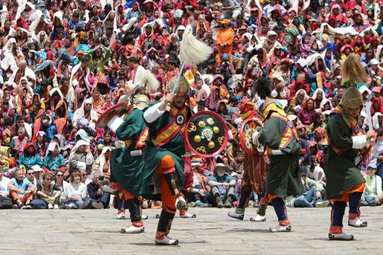 Mask dancers performing before a crowd at a tshechu