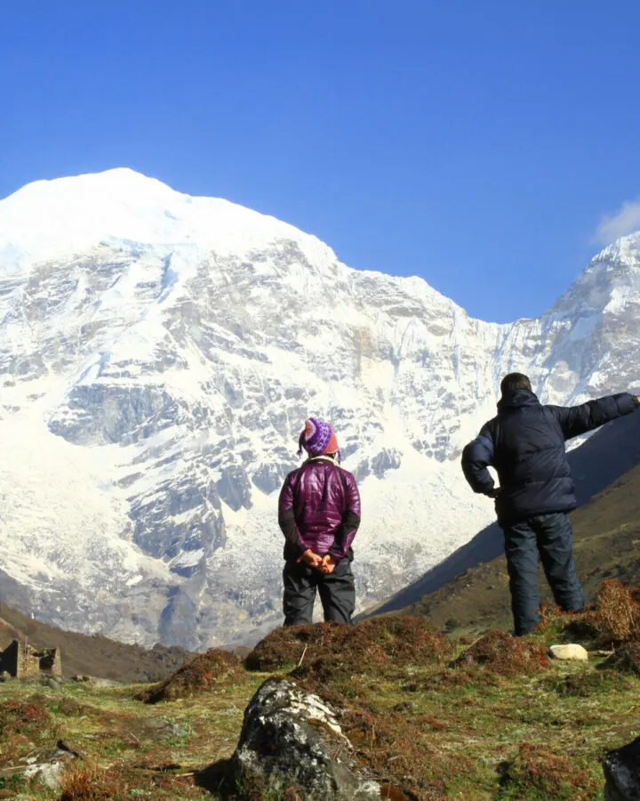 Trekkers looking out at a snow-covered Himalayan peak in Bhutan