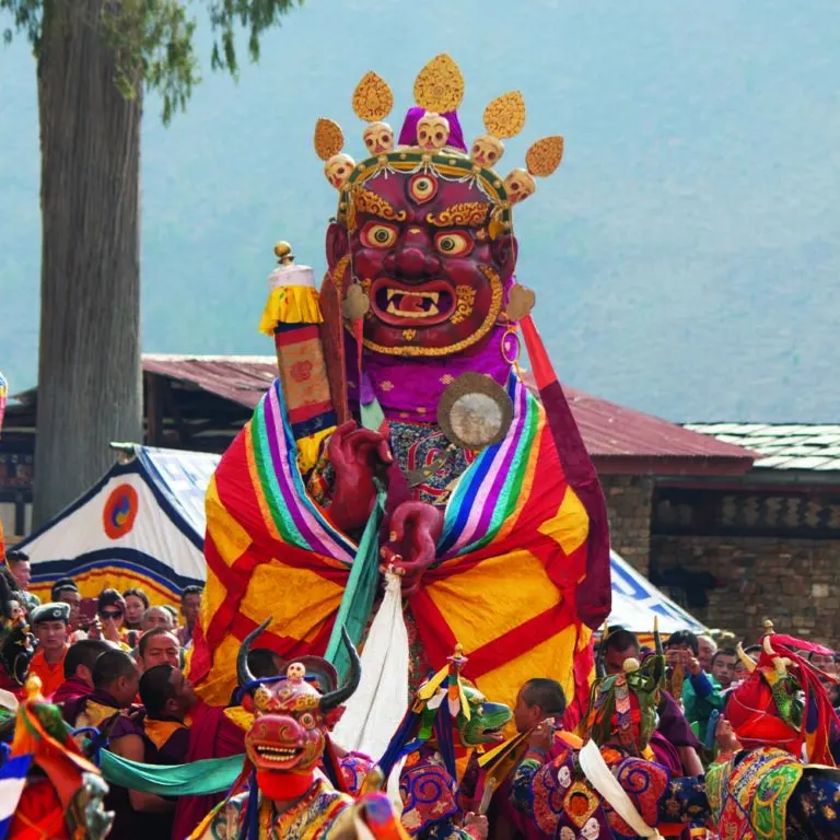 Masked dancer in a colourful costume at the Paro Tshechu